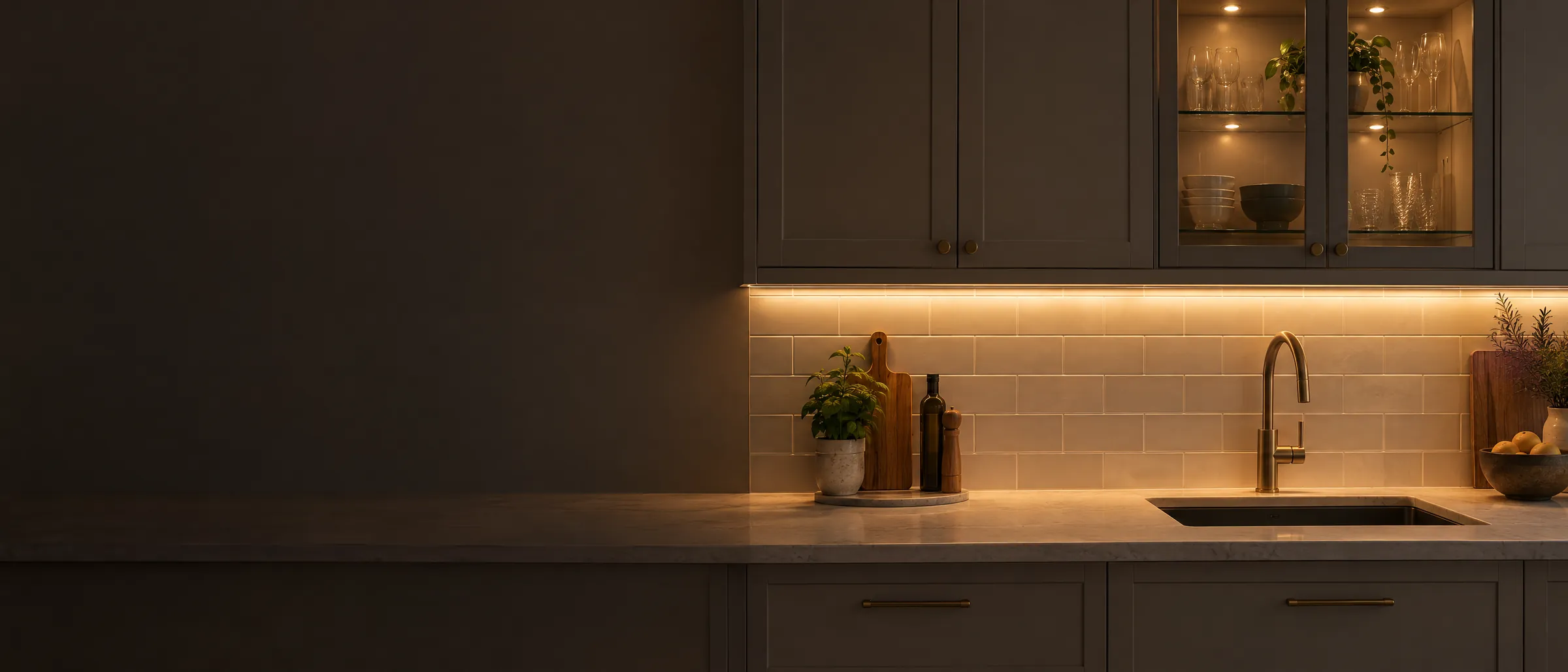 Keuken in de avond met LED-verlichting onder de bovenkasten en een verlichte vitrinekast